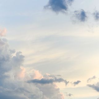 A serene sky filled with soft gray and pink clouds against a light blue backdrop.